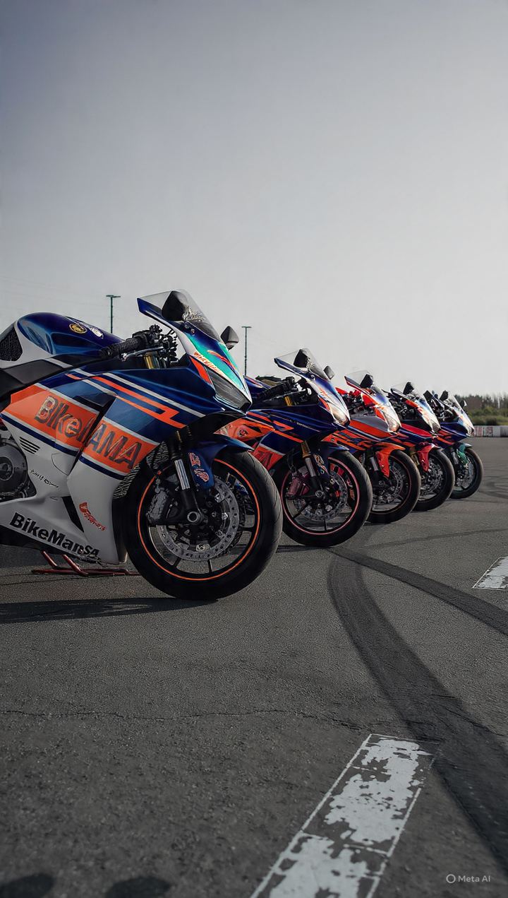 A long row of sport bikes parked on a racetrack